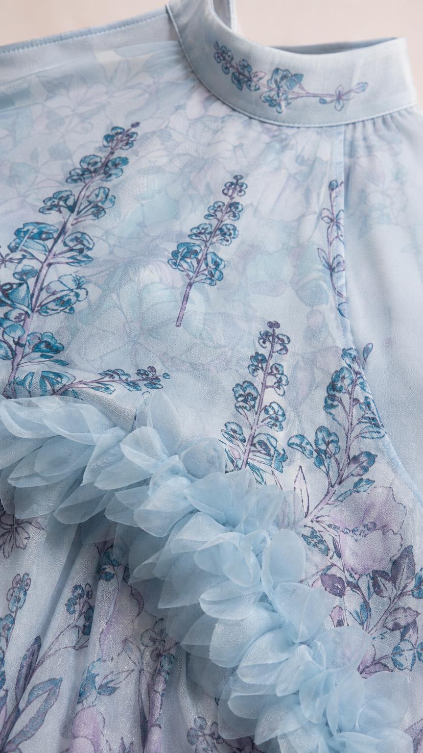 Close-up detail of high neckline and textured ruffles on light blue dress