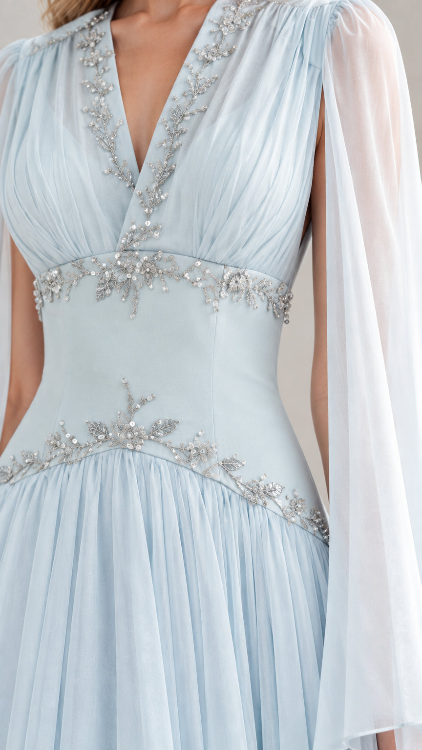 Close-up detail of silver beaded embellishments and pleated V-neck bodice on sky blue gown