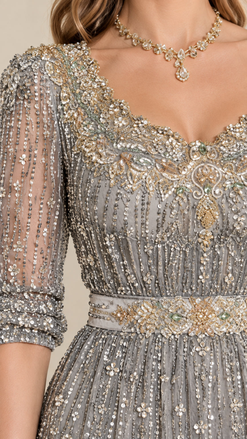 Close-up detail of ornate crystal neckline and embellished waistband on silver gown