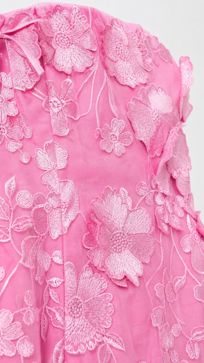Close-up detail of pink 3D floral embroidery and appliques