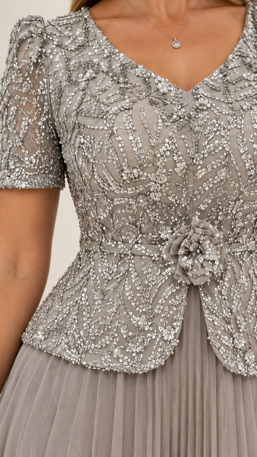 Close-up of slate grey sequined embroidery, V-neckline, and floral waist applique