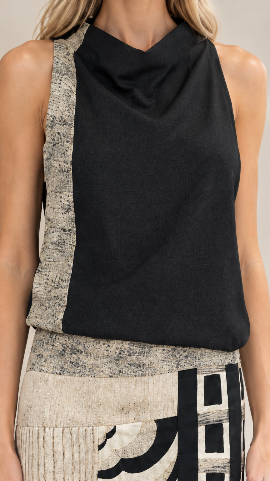 Close-up detail of cowl neckline and textured waist accent on black maxi dress