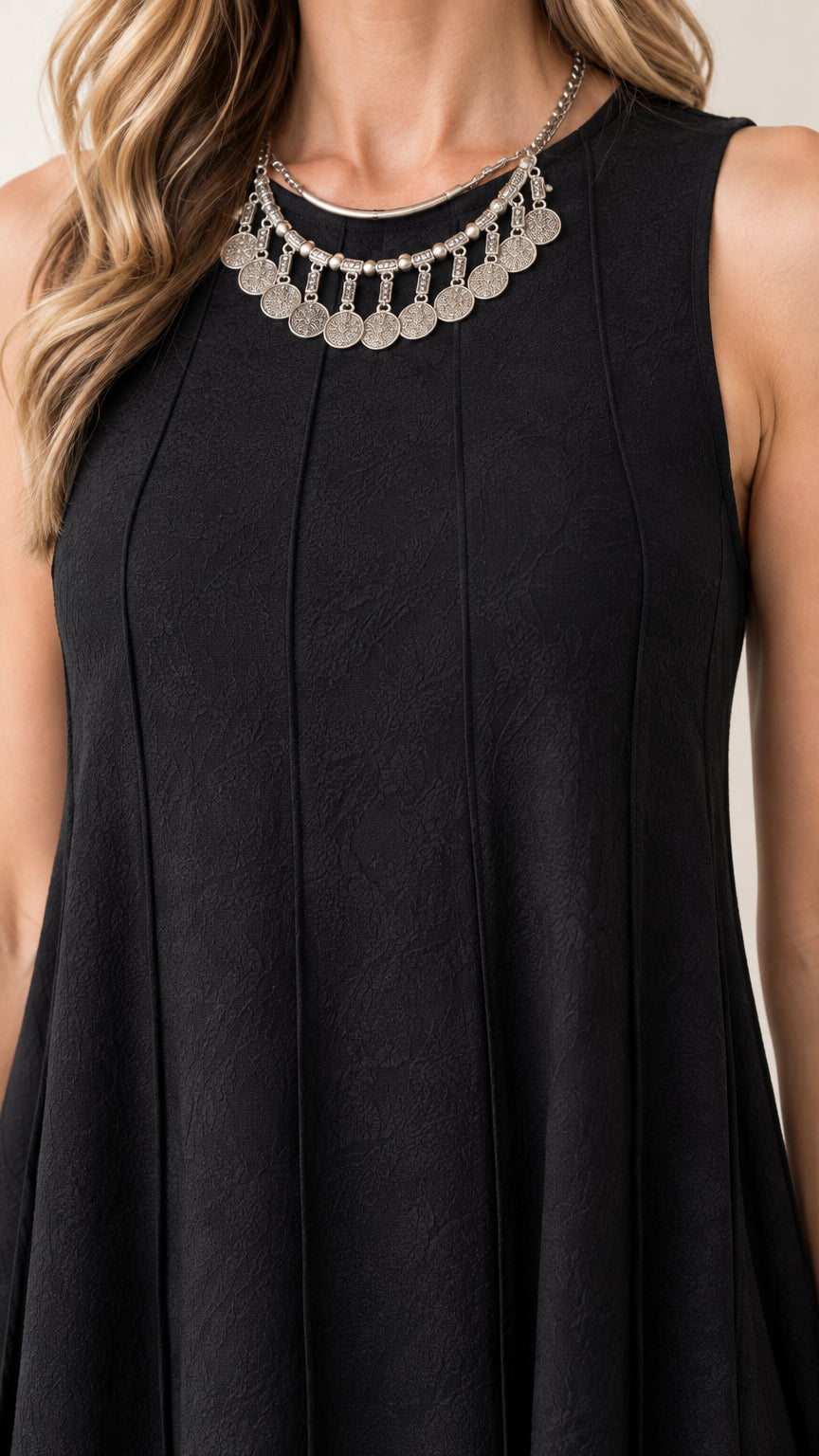Close-up of black sleeveless dress bodice showing textured fabric and panel seam craftsmanship