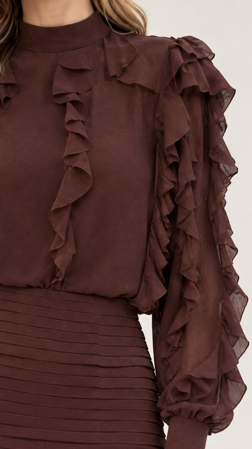 Close-up detail of mock neckline, sleeve ruffles, and ruched bodice in Chocolate Brown