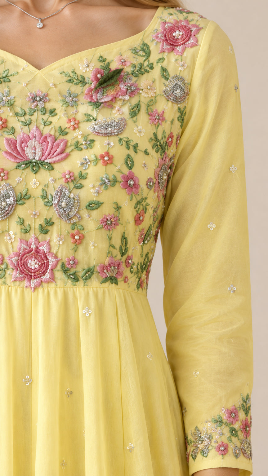 Close-up detail of delicate floral embroidery on yellow gown bodice