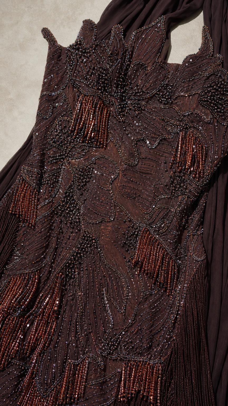 Close-up of intricate brown beadwork and embroidery on dress bodice