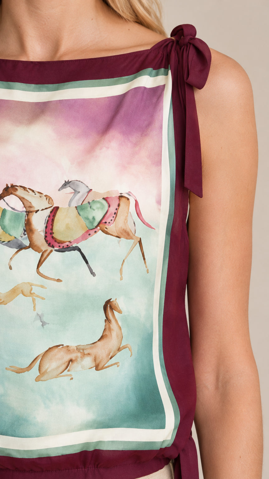 Close-up detail of equestrian scarf pattern and bow tie shoulder strap in burgundy