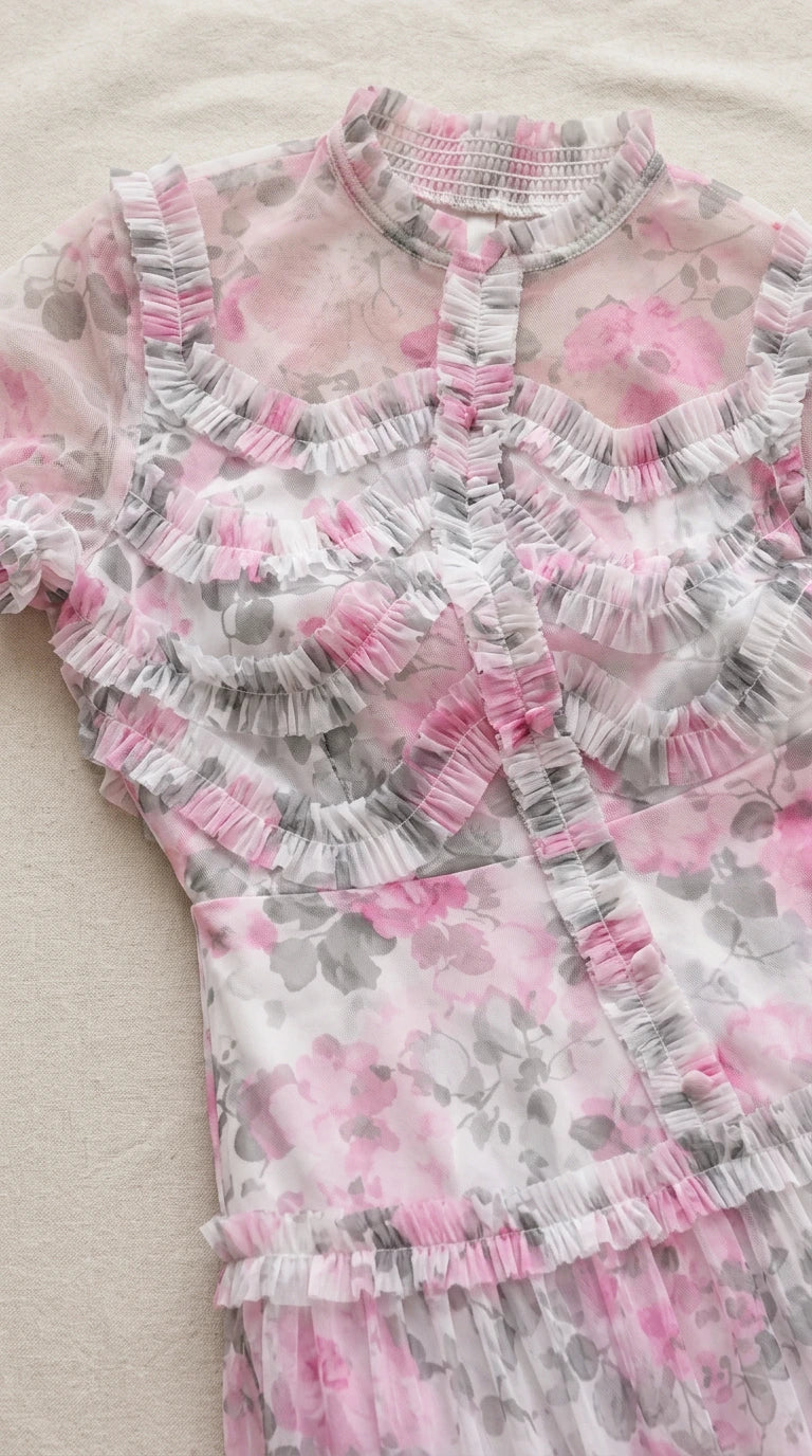 Close-up detail of the ruffled stand collar and bodice button trim on pink floral fabric
