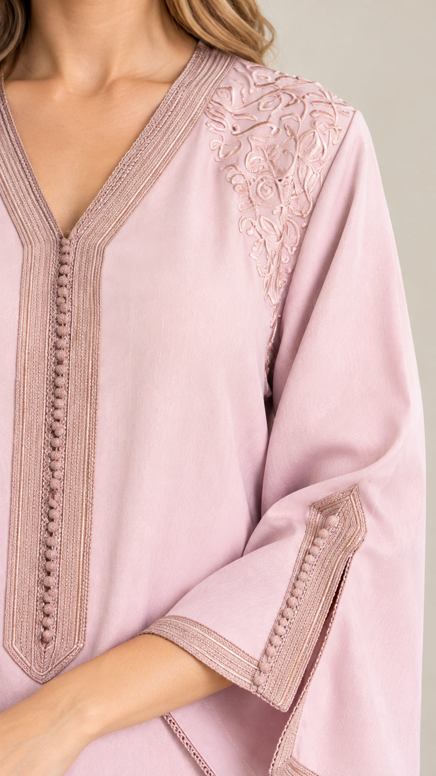 Close-up of V-neckline braided trim, textured buttons, and delicate floral shoulder embroidery on Dusty Pink kaftan