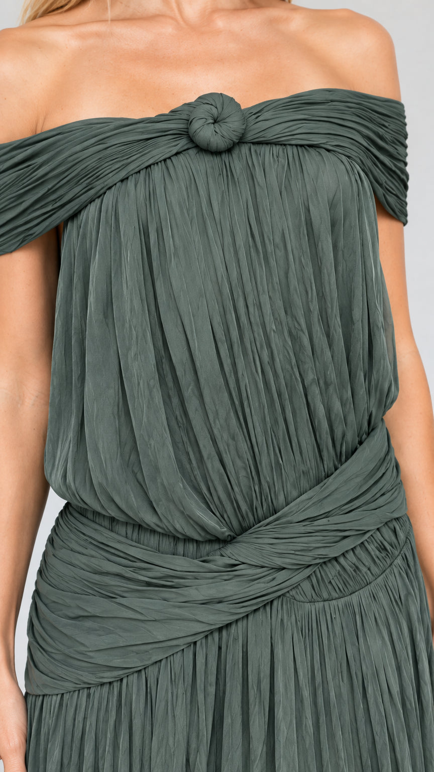 Close-up detail of textured pleating, neckline knot, and draped waist sash