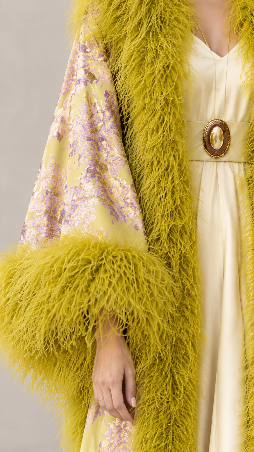 Close-up detail of chartreuse floral jacquard brocade and plush feather cuff
