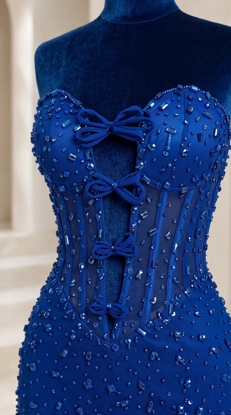 Close-up detail of sheer boned corset bodice with beads and bow accents in royal blue