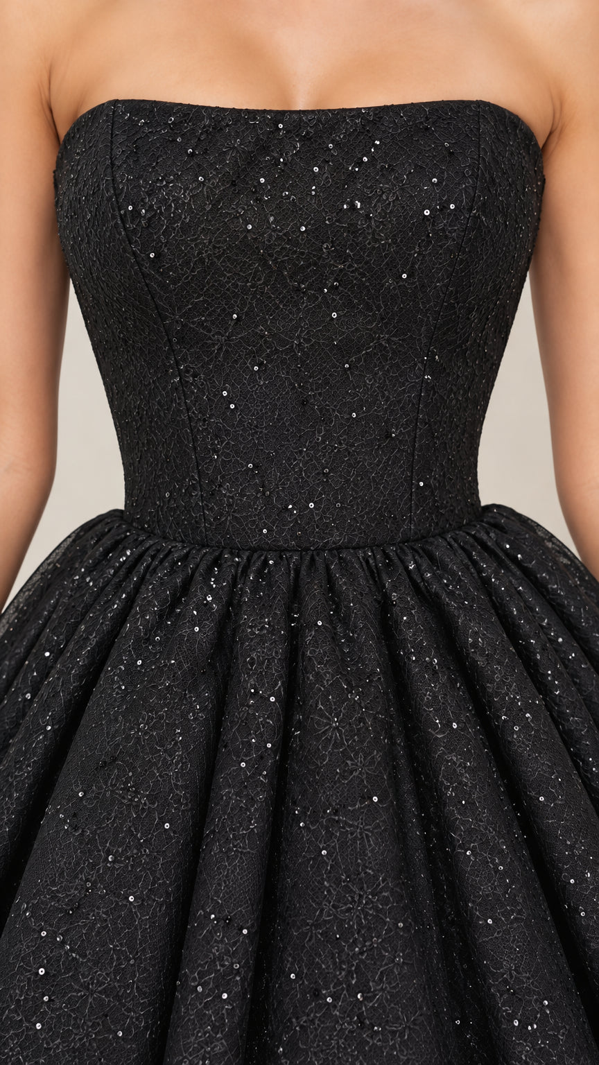 Close-up detail of black strapless fitted bodice with shimmering lace texture