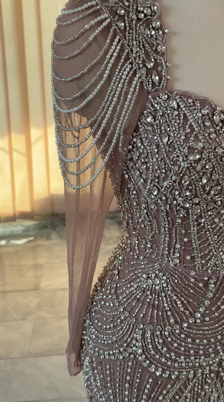 Close-up of intricate crystal beading and draped pearl shoulder sleeve detail