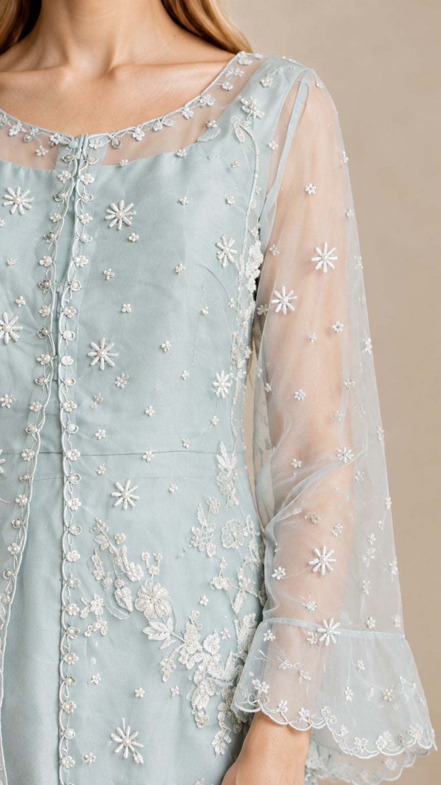Close-up detail of sheer embroidered sleeve and floral applique on Light Blue tunic