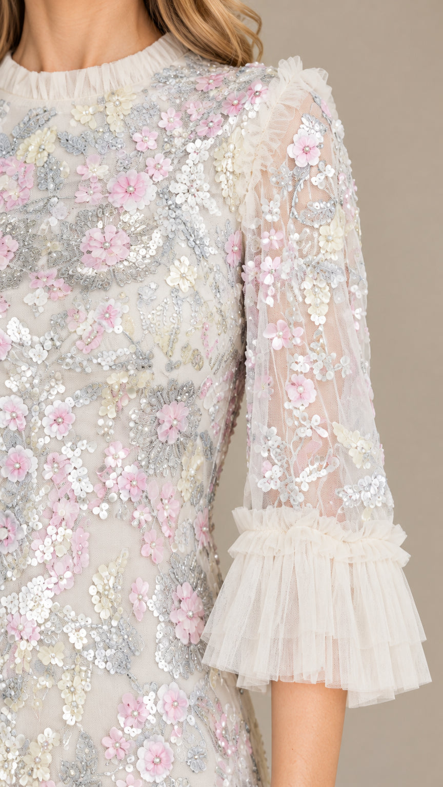 Close-up detail of floral sequin embroidery and pleated tulle ruffle sleeve cuff
