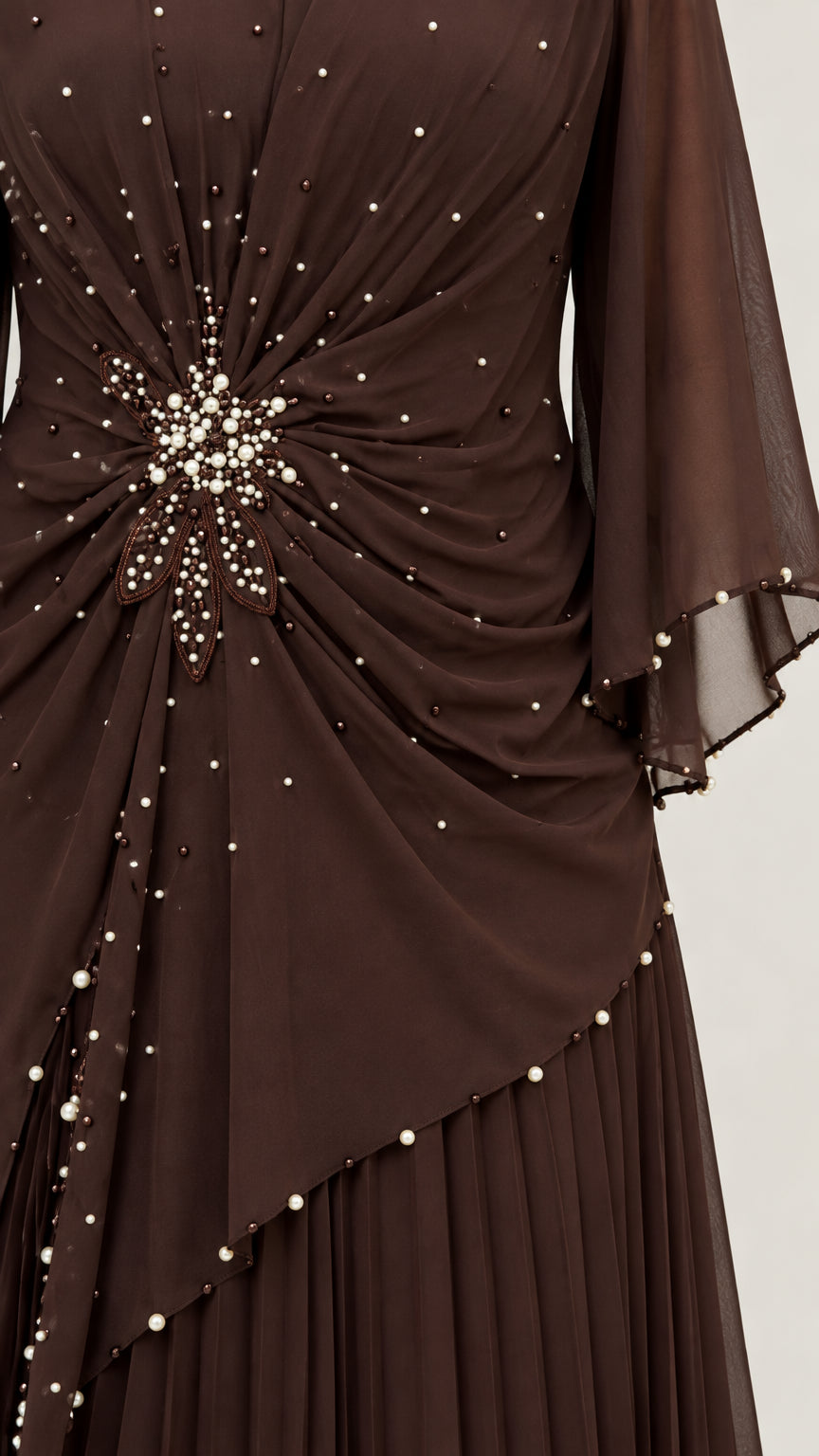 Close-up detail of pearl and bead starburst embellishments on dark brown chiffon bodice