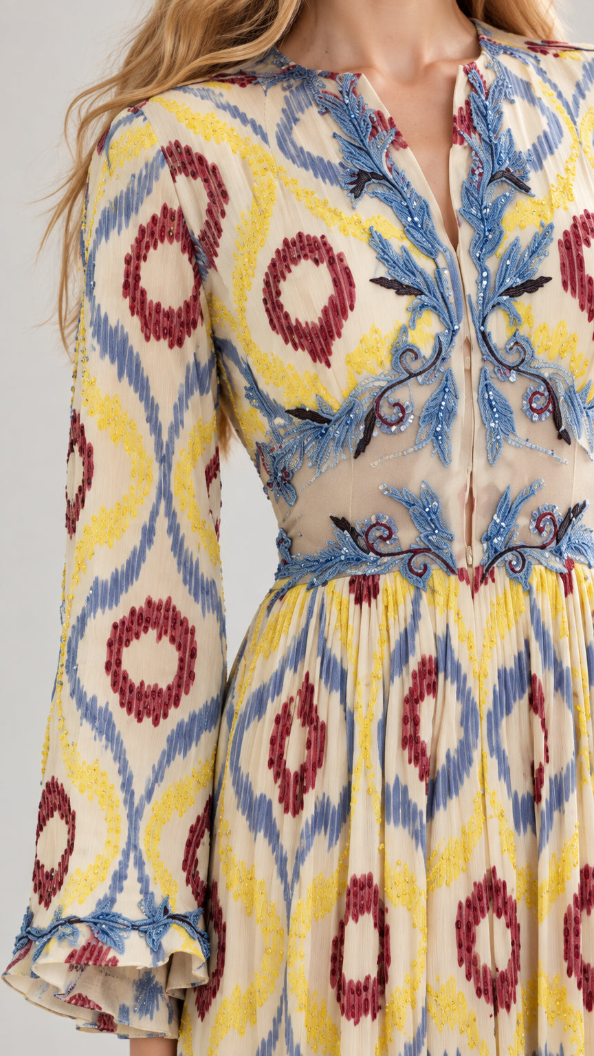 Close-up detail of embroidered split neckline and bell sleeve on yellow ikat dress