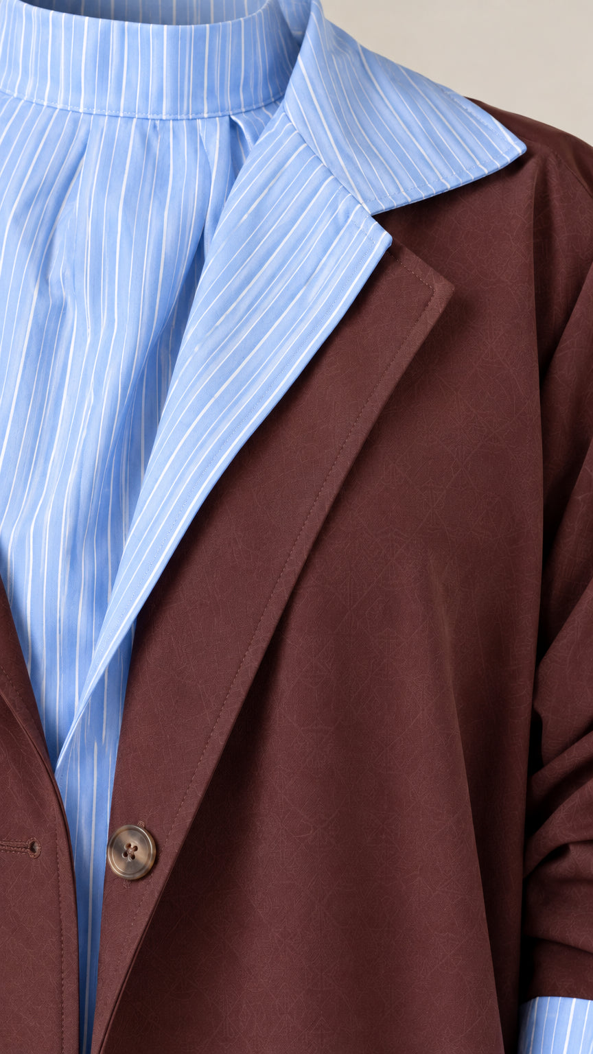 Close-up detail of notched lapel, pinstripe contrast collar, and button fastening