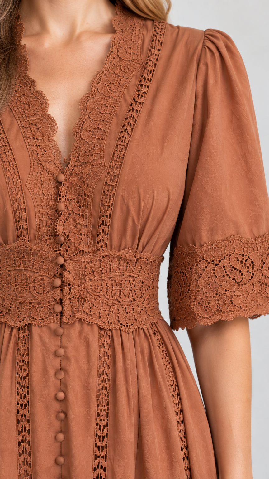 Close-up detail of crochet lace trim on neckline and waist of rust brown maxi dress