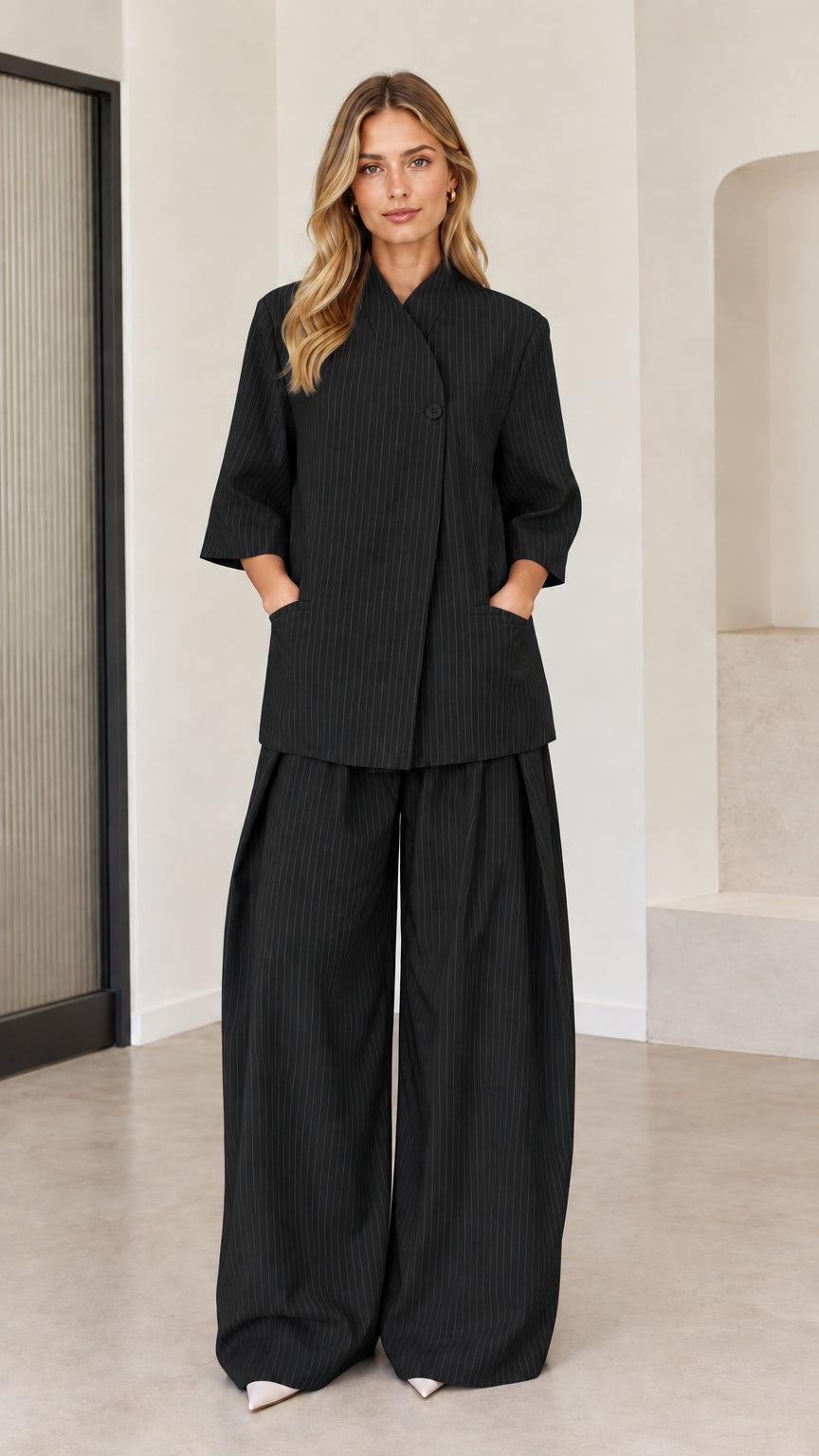Black pinstripe women's two-piece asymmetric top and wide-leg trousers outfit