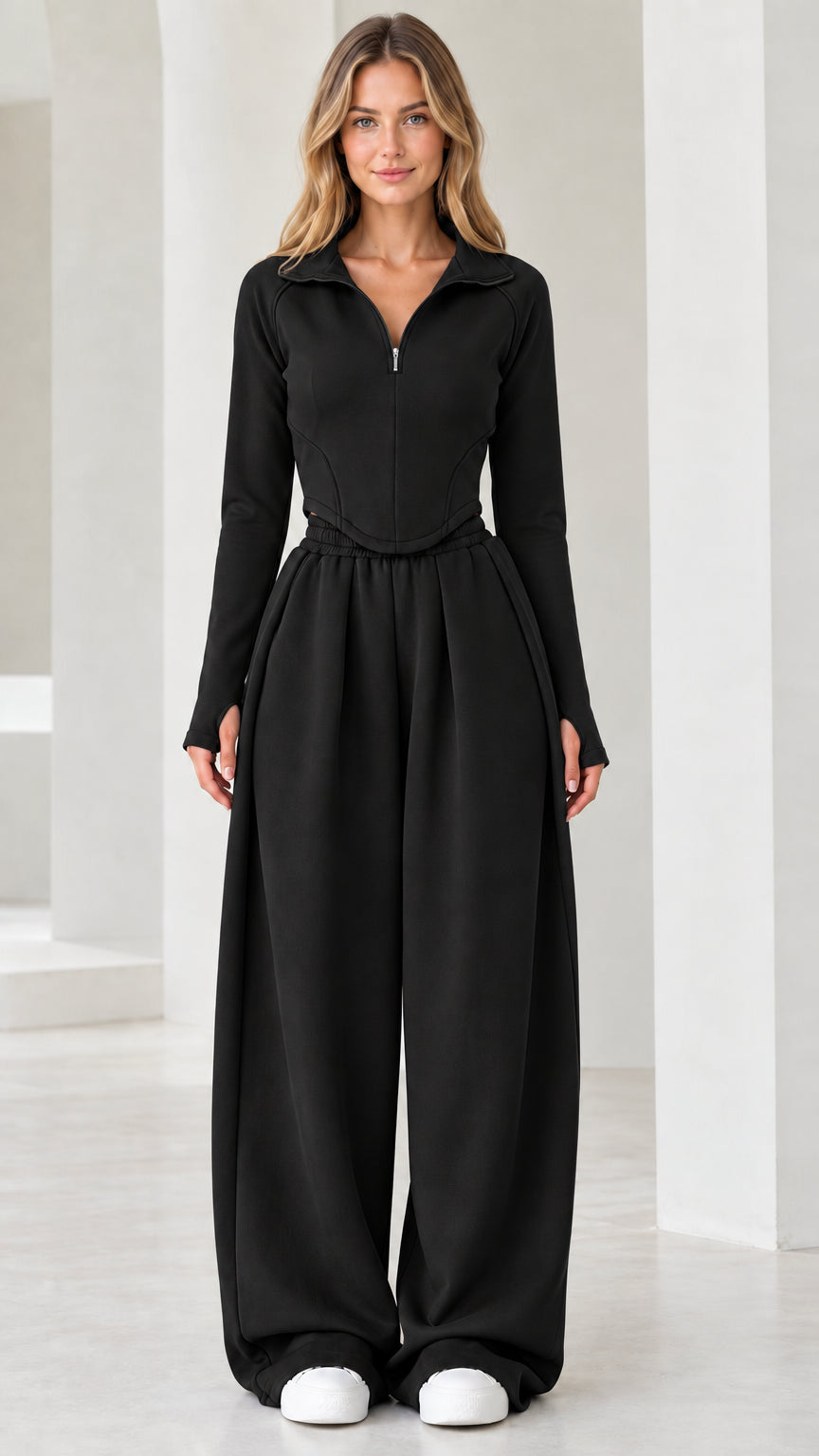 Full-length front view of model wearing black quarter-zip top and wide-leg pants set