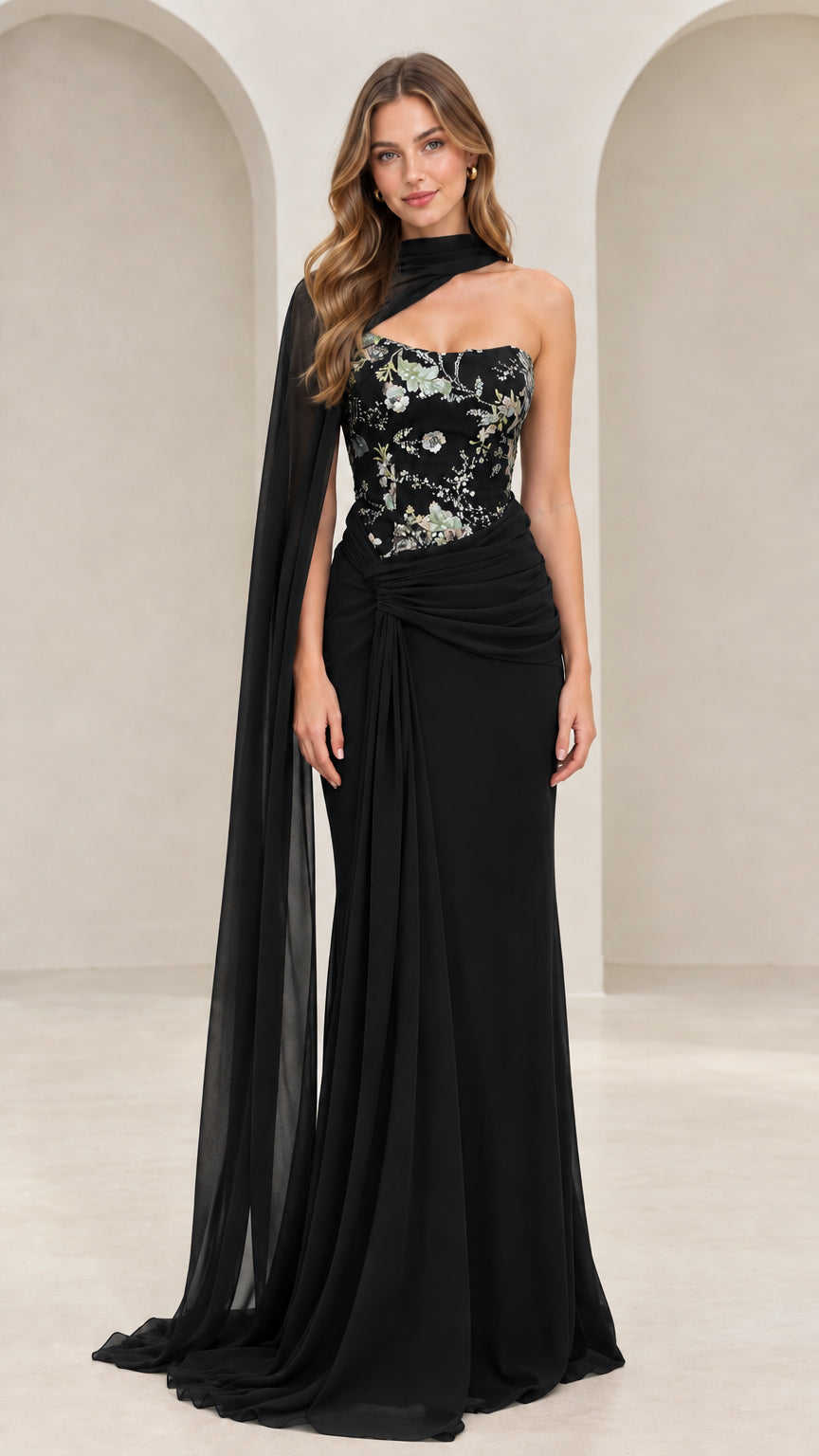 Front view of black floral embroidered evening dress with draped shoulder cape