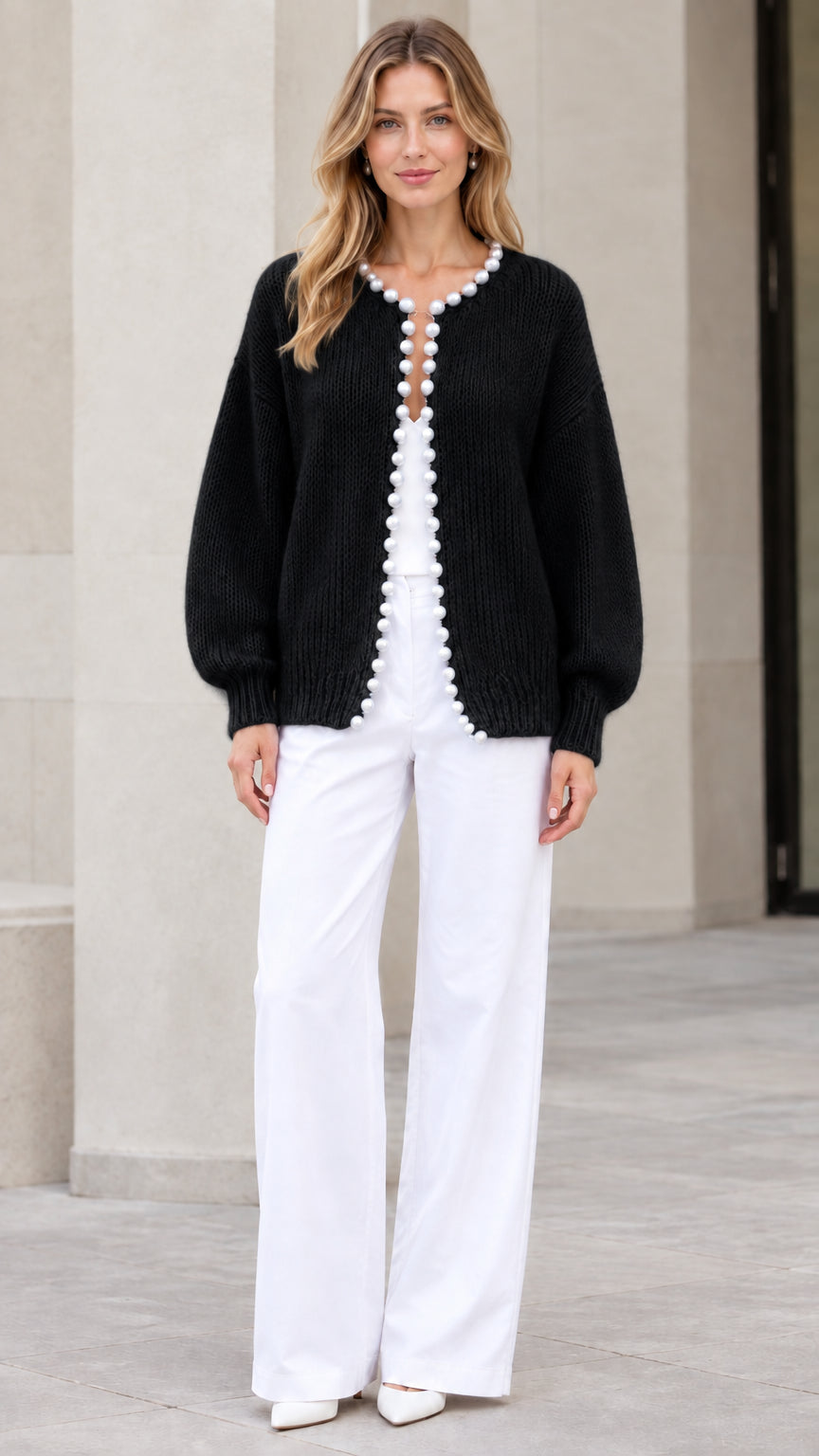 Model wearing Black pearl-trimmed knit cardigan sweater with white trousers