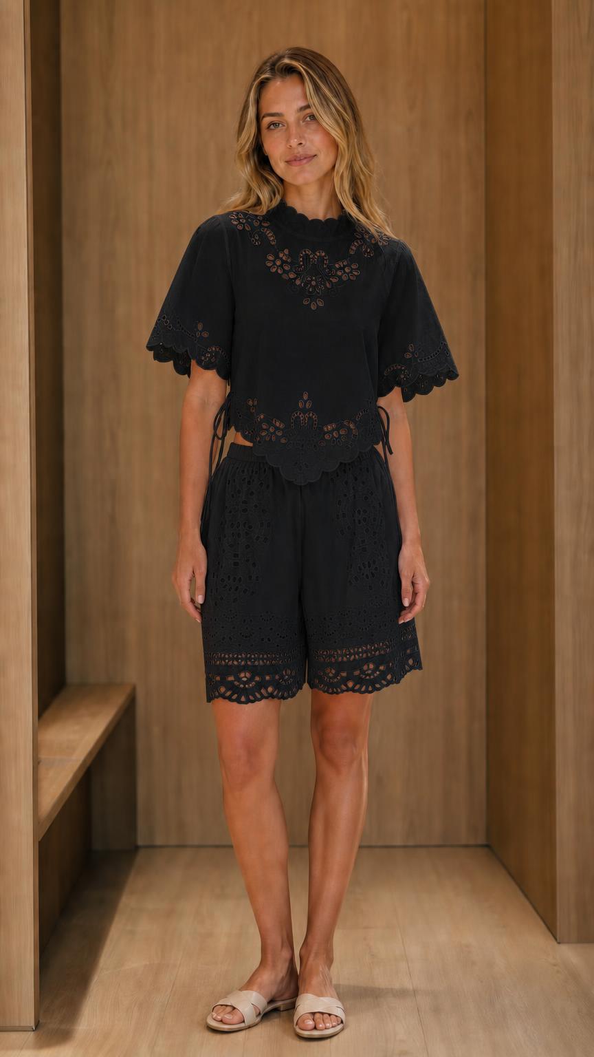 Model wearing black eyelet embroidered top and shorts set