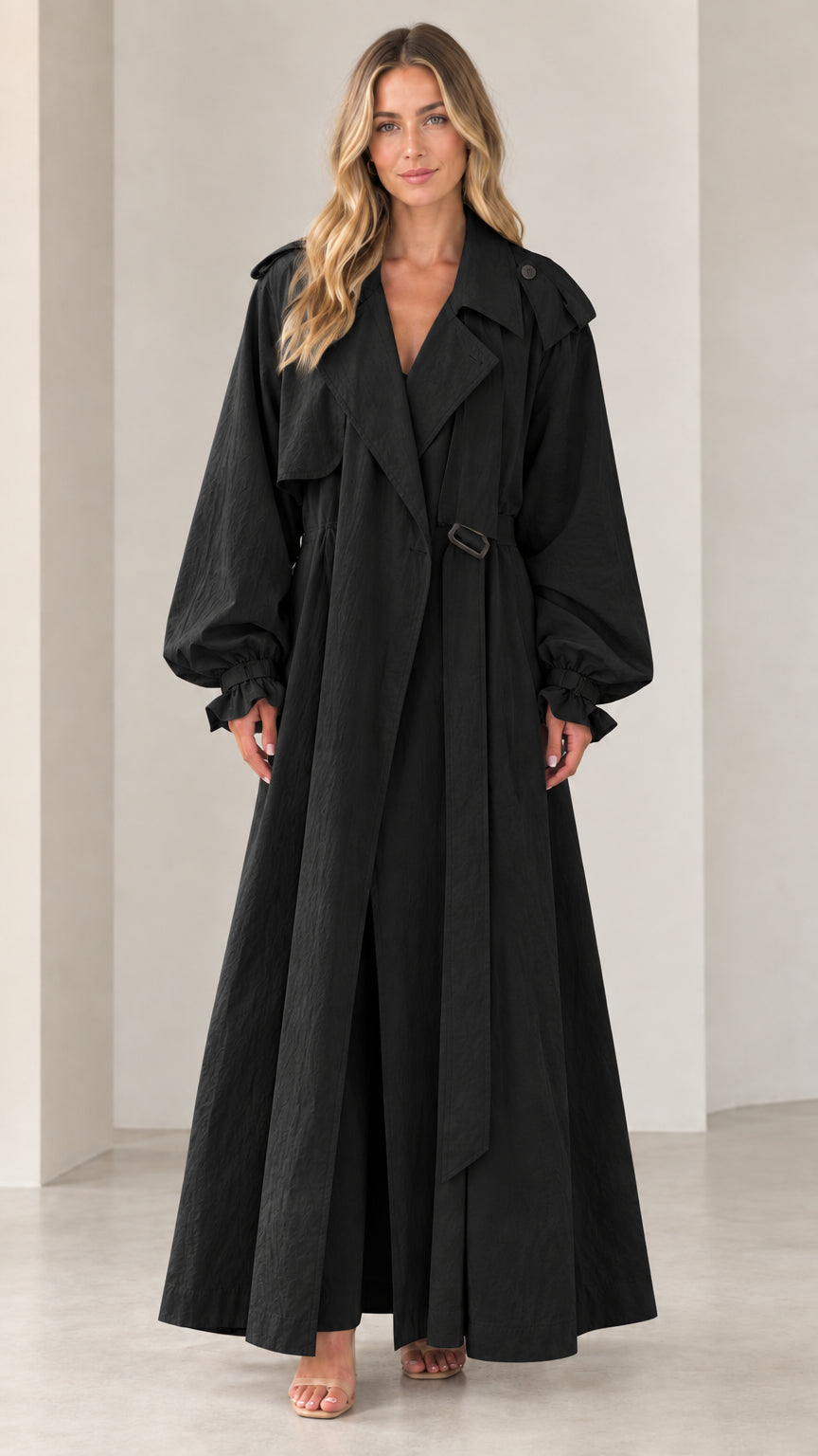 Front view of woman wearing full-length black belted maxi trench coat