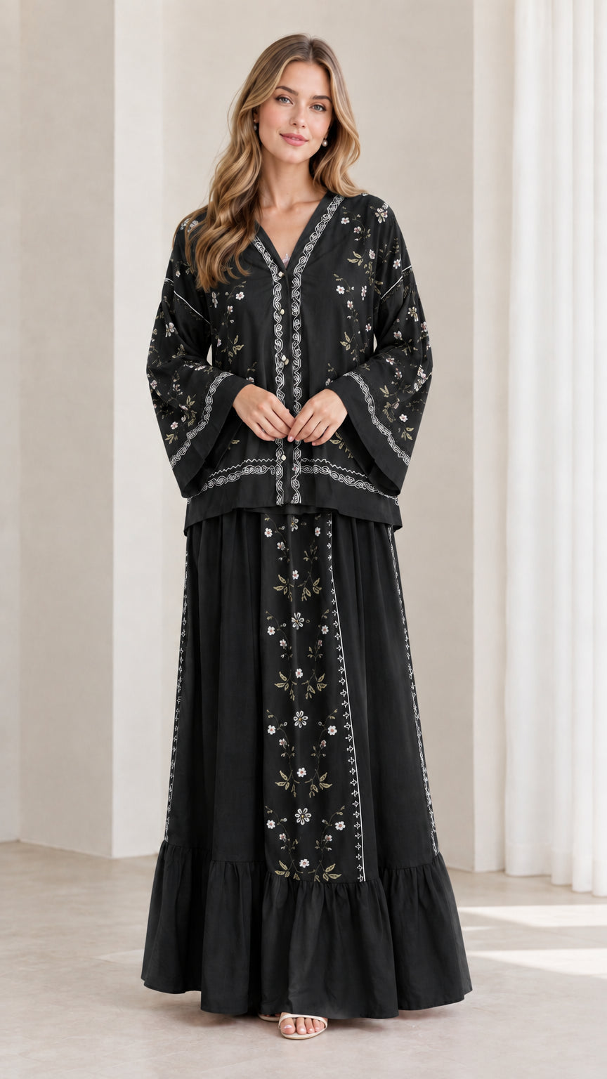 Model wearing black floral embroidered tunic top and tiered maxi skirt set