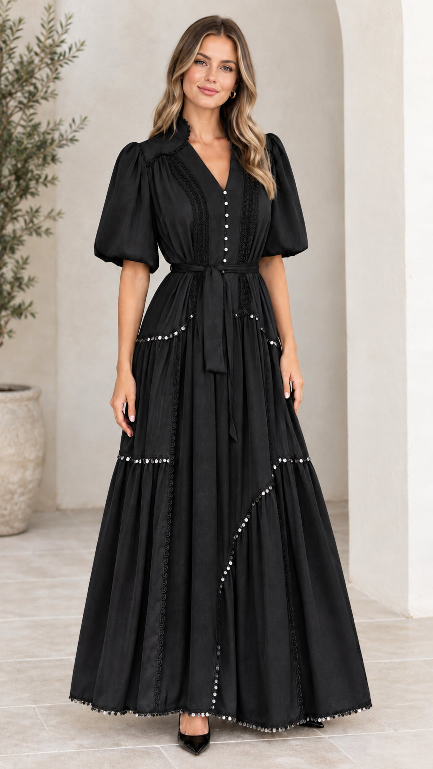 Front view of woman wearing black V-neck puff sleeve tiered maxi dress