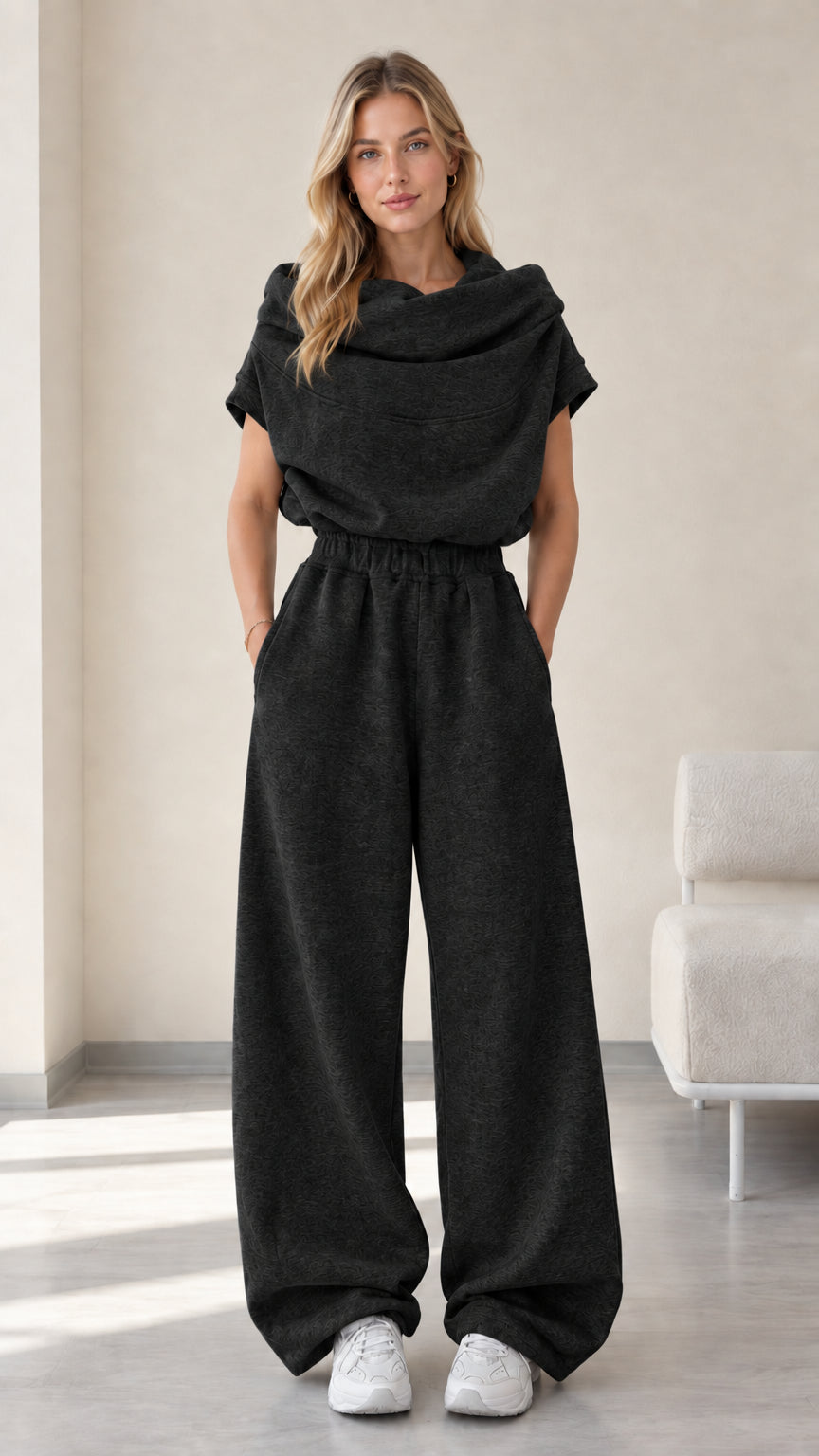 Full-length studio view of model wearing charcoal black cowl neck top and wide-leg pants set