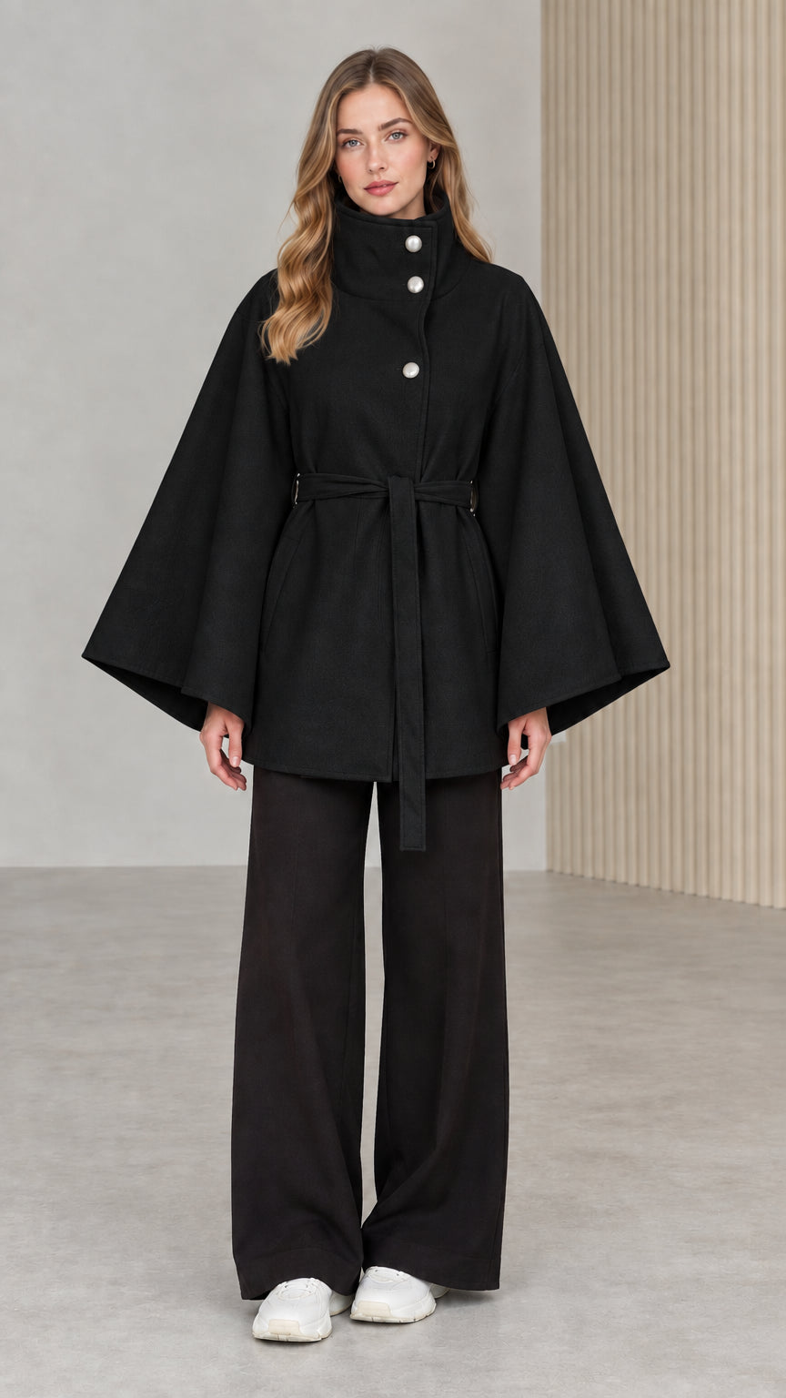 Front view of model wearing black high neck belted cape coat