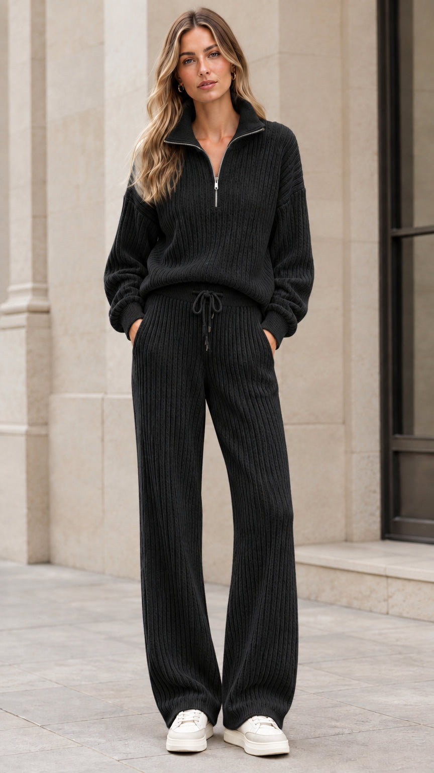 Front view of woman wearing black ribbed knit half-zip sweater and wide-leg pant set