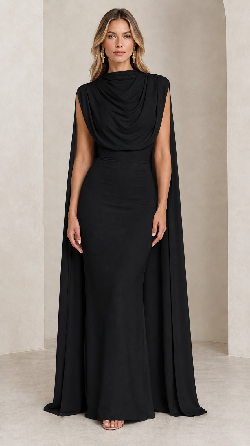 Front view of model wearing the black draped cowl neck cape evening gown