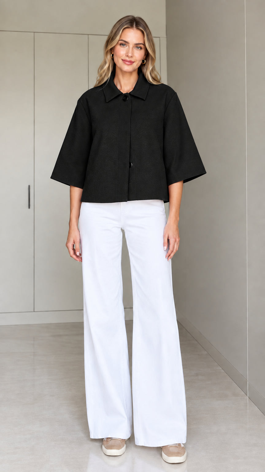 Front view of a woman wearing the cropped half-sleeve swing jacket in black