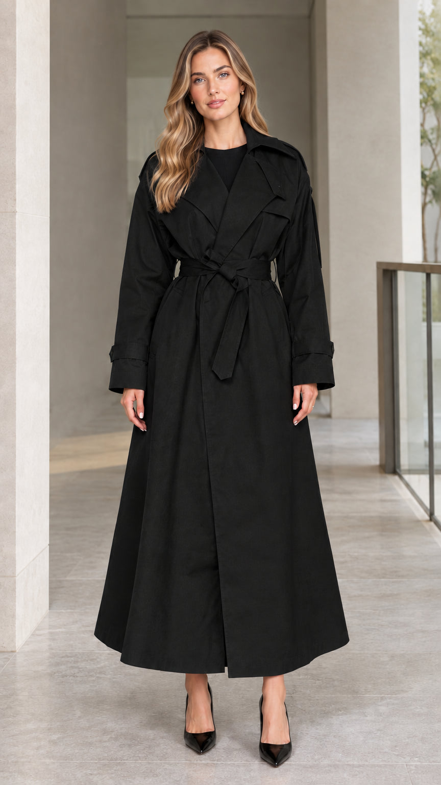 Front view of model wearing Black full-length belted maxi trench coat
