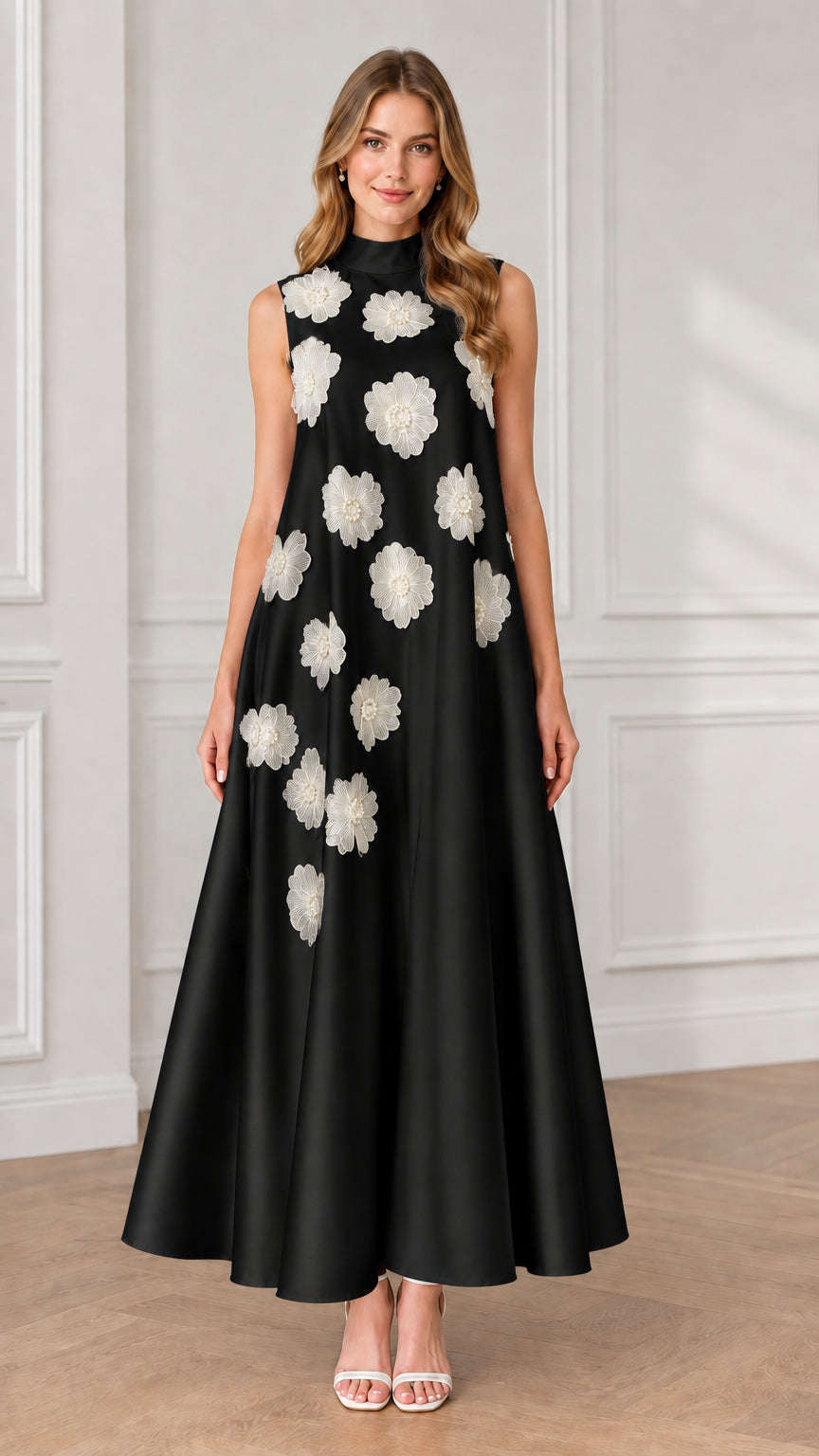 Model wearing black sleeveless high neck maxi dress with contrasting white floral appliqués