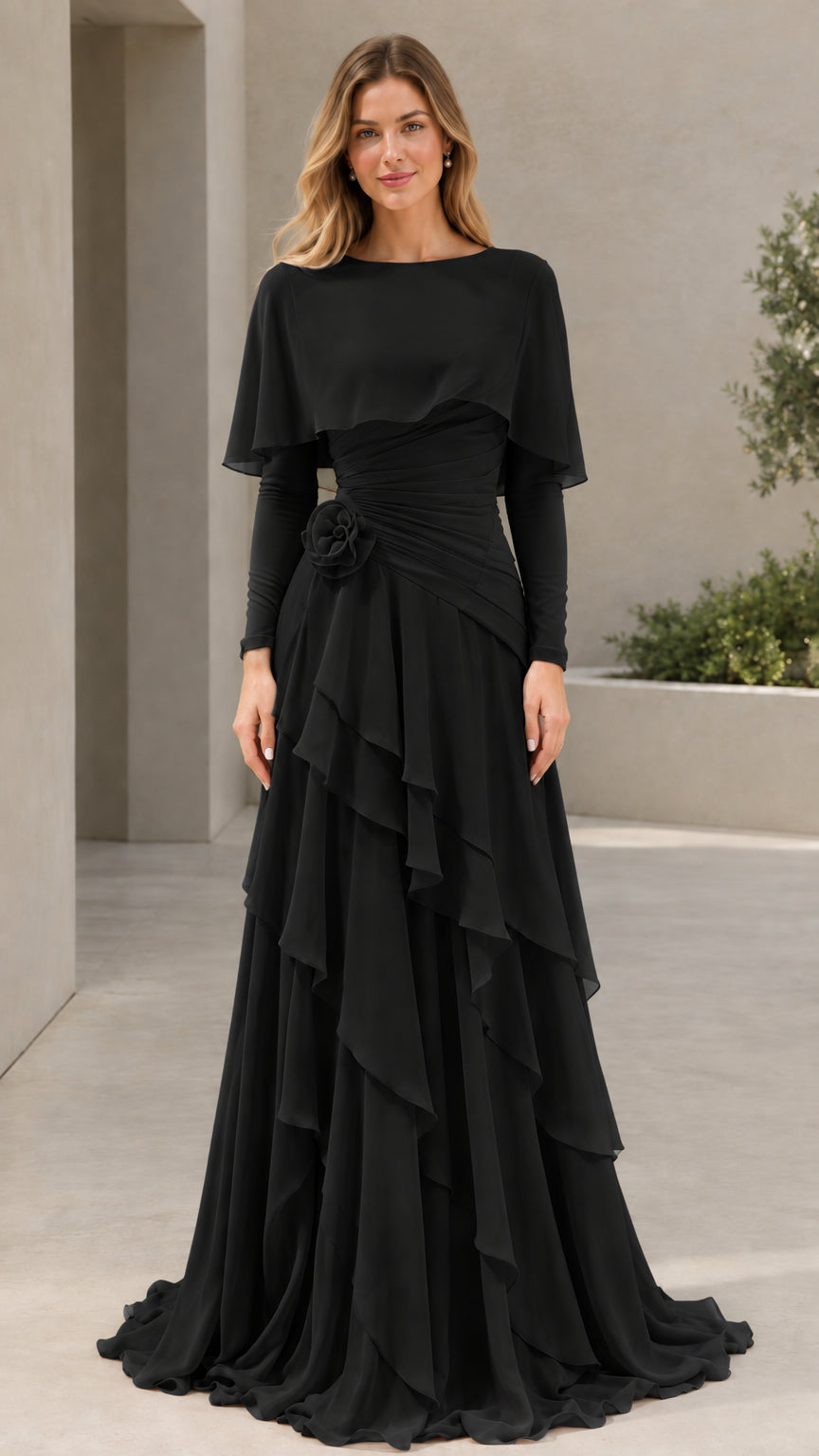 Woman wearing Black long sleeve capelet tiered evening gown