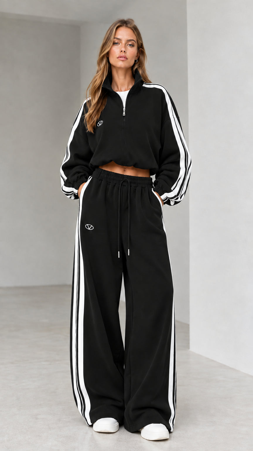 Front view of woman wearing black cropped quarter-zip tracksuit set
