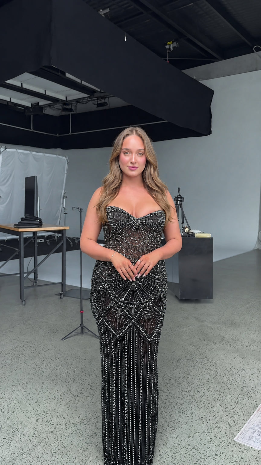 Front view of model wearing strapless beaded black formal evening gown