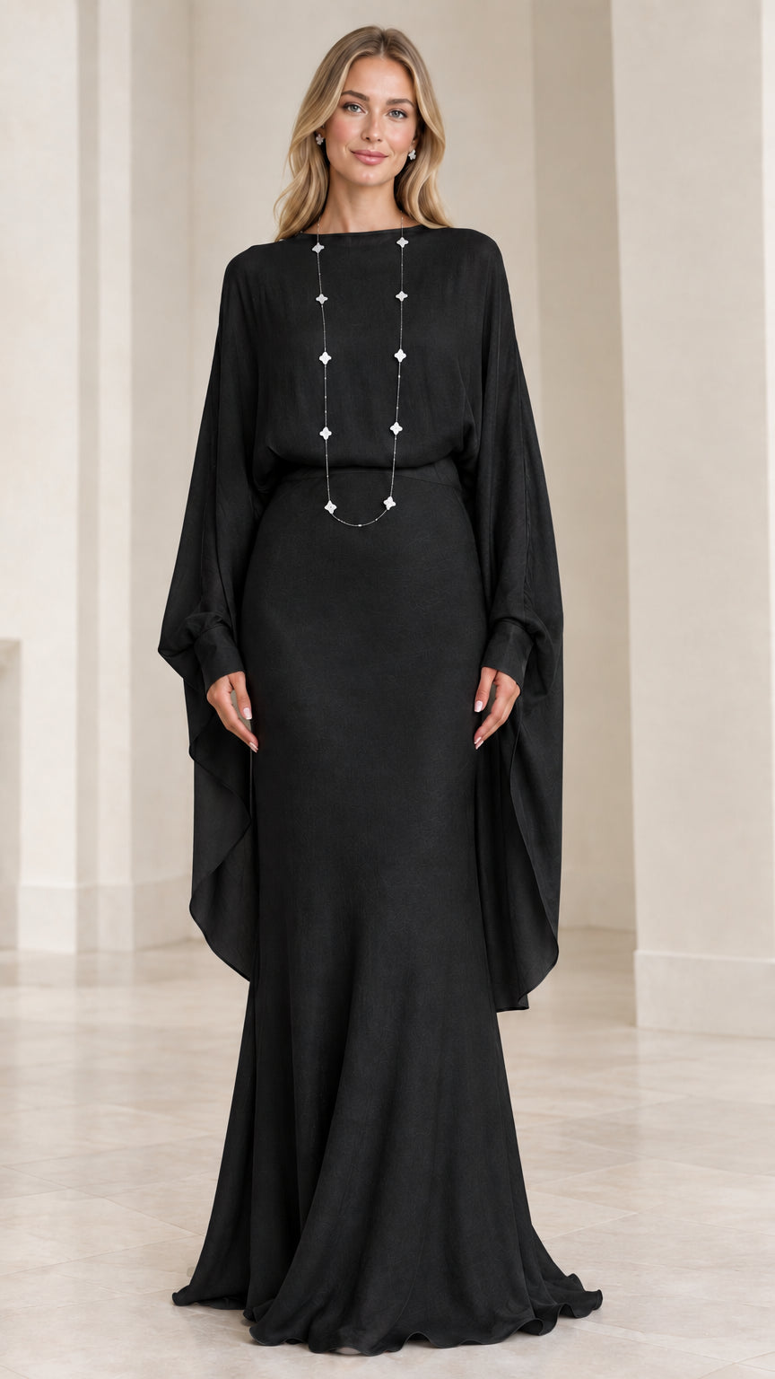 Front view of model wearing black draped cape-sleeve maxi evening dress