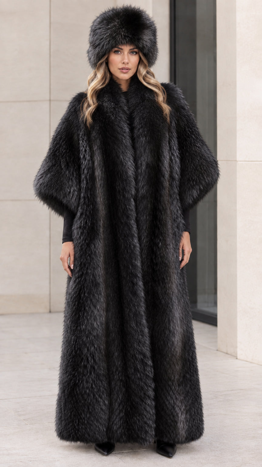 Model wearing dramatic full-length black faux fur maxi coat and hat
