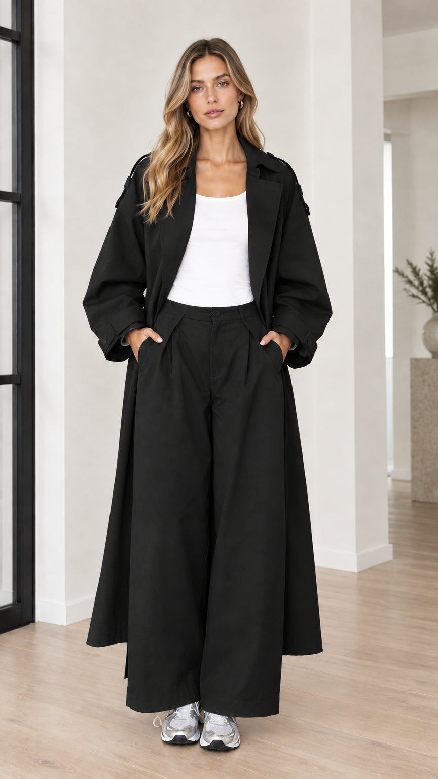 Woman wearing classic black oversized maxi trench coat and wide-leg pants two-piece set