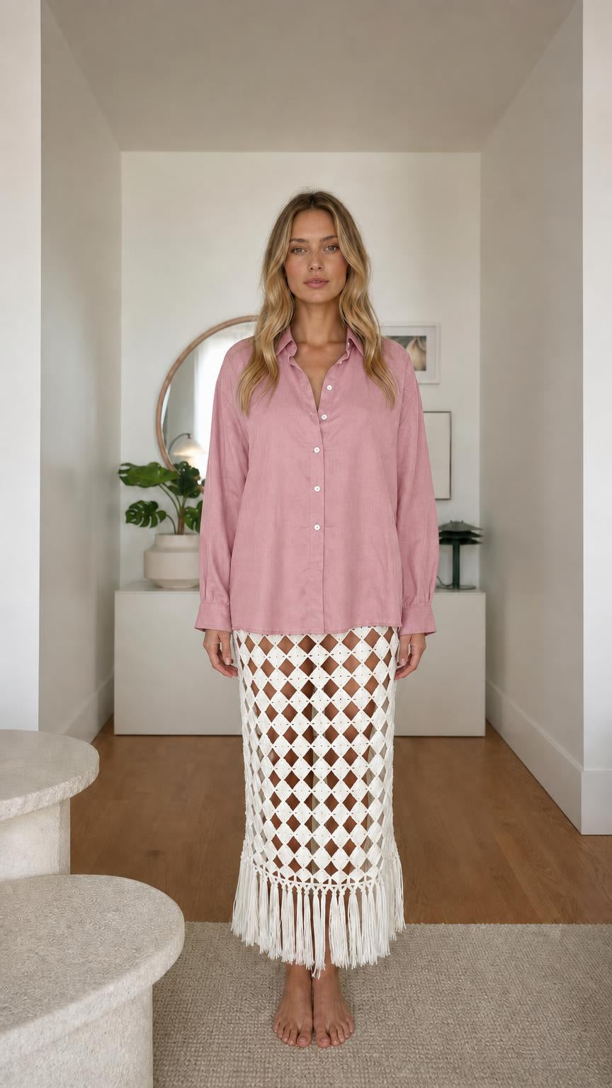 Model wearing pink long sleeve button-down shirt and patterned fringe skirt