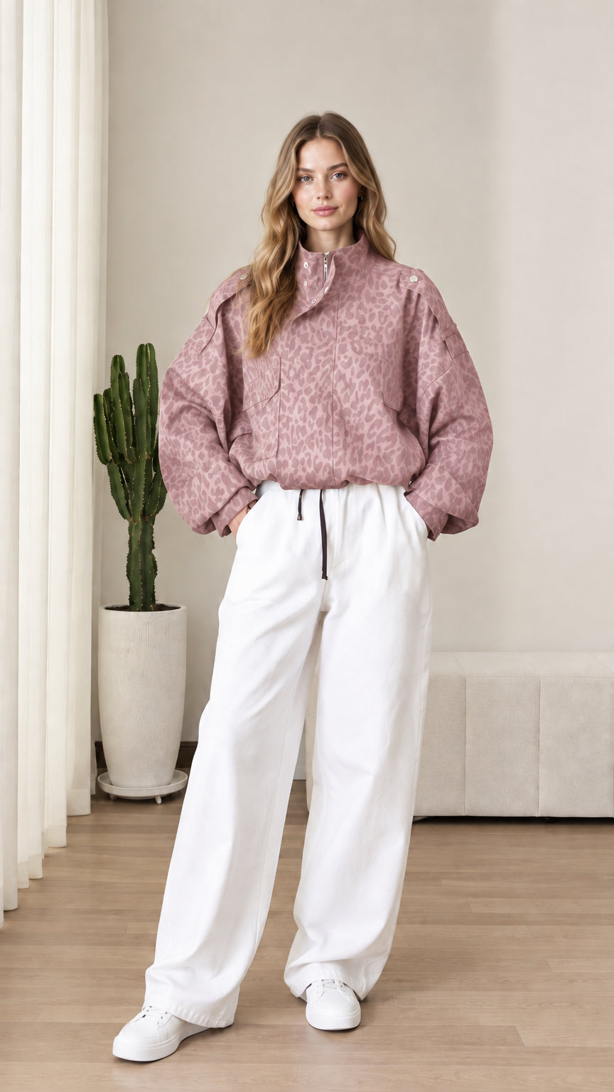 Front view of model wearing dusty rose leopard print pullover jacket with white pants