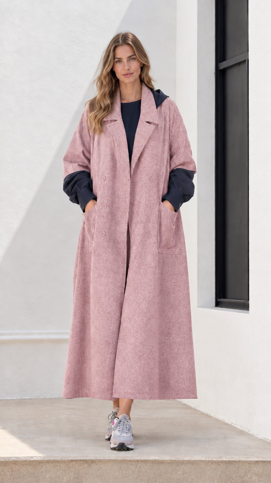 Full-length front view of woman wearing dusty pink hooded maxi trench coat