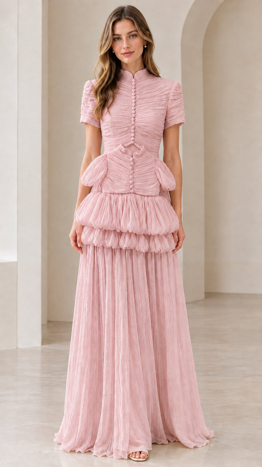 Front view of model wearing dusty pink mock neck tiered pleated formal dress