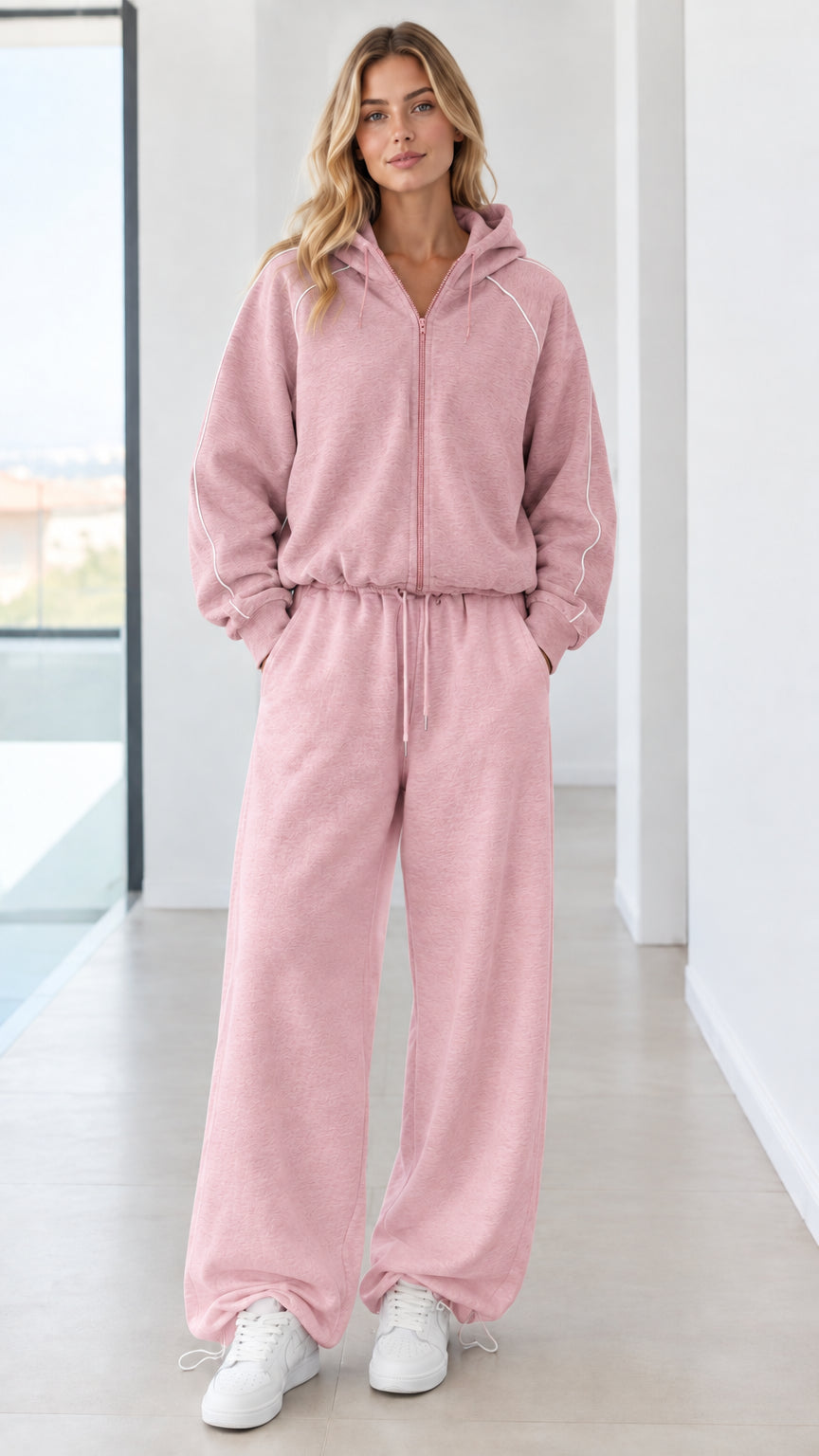 Full body studio shot of model wearing dusty pink zip-up hoodie and wide-leg sweatpants set